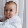 A cute baby looking over a parent's shoulder while wrapped snugly in a soft Blue Check Knitted Chenille Blanket.
