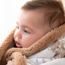 Side profile view of an infant snugly wrapped in the textured brown fleece lining of the Cuddly Bear jersey baby blanket.