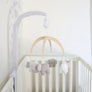 Straight-on view of the Elephant Heritage Musical Mobile attached to a neutral white baby crib in a minimalist nursery setting.