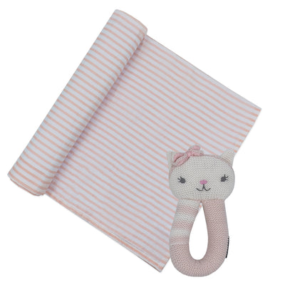 Product shot of a baby girl newborn gift set featuring a white cotton muslin swaddle blanket printed with classic pink stripes, partially unrolled next to the coordinating
