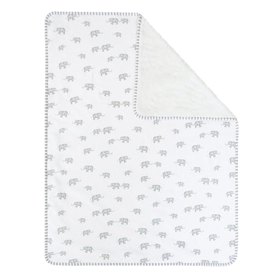 Full overhead view of the Elephant Heritage jersey sherpa baby blanket laid flat, displaying the continuous pattern scale of miniature grey elephants across the soft white fabric surface with one corner folded down.