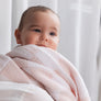 Close-up of a baby resting on a parent's shoulder, wrapped in a cozy Pink Check Knitted Chenille Blanket.