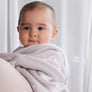 Baby wrapped in a soft, cozy Knitted Chenille Blanket in Grey Galaxy with a celestial star pattern.