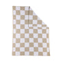 Folded corner detail of a Taupe Check Knitted Chenille Blanket against a white background, highlighting the premium weave of the soft knit fabric.