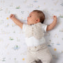 Cute baby stretching and resting comfortably on the breathable white Goosey Goosey printed crib sheet.