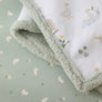 Close-up detail of the plush sage green sherpa border and soft cotton jersey fabric of the Goosey Goosey baby blanket.