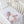 High angle view of a baby lying in a white wooden crib looking up at the hanging plush toys of the Elephant Heritage Musical Mobile.