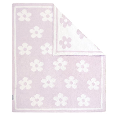 Flat lay studio view of the Chenille Baby Blanket in Purple Flower style, showcasing a plush lavender pink and white retro floral pattern with a solid border and a folded corner revealing the neat, reversible knit texture.